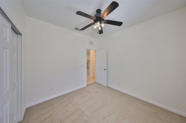 unfurnished bedroom featuring ceiling fan, a closet, and light carpet