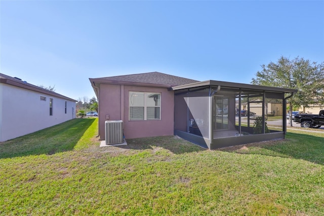 back of house featuring a sunroom, a yard, and central AC