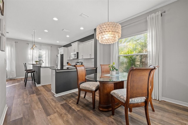 dining space featuring plenty of natural light, dark hardwood / wood-style floors, and a chandelier