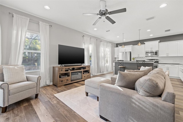 living room featuring wood-type flooring and ceiling fan