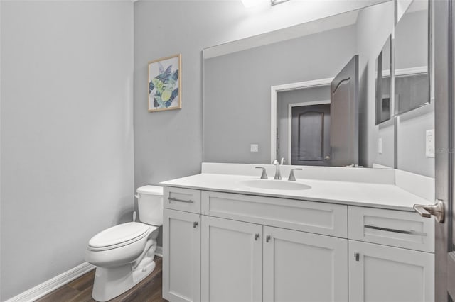 bathroom with vanity, hardwood / wood-style floors, and toilet