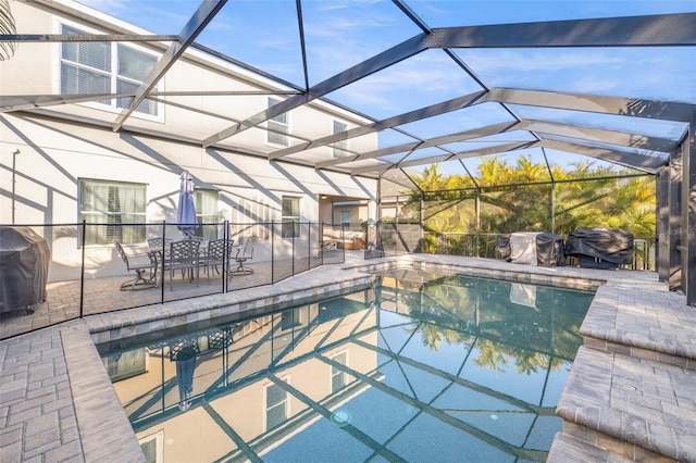 view of pool with a lanai, area for grilling, and a patio area