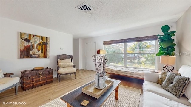 living room featuring a textured ceiling and light wood-type flooring