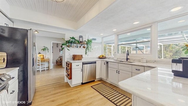 kitchen with a healthy amount of sunlight, sink, white cabinets, and appliances with stainless steel finishes