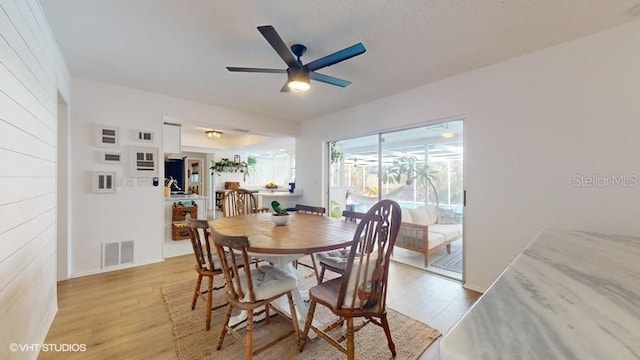 dining area with ceiling fan and light hardwood / wood-style floors