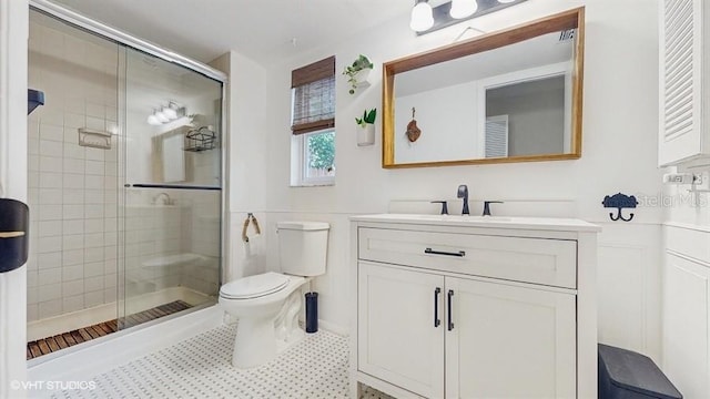 bathroom featuring vanity, toilet, and a shower with shower door