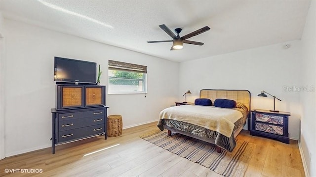 bedroom featuring wood-type flooring, ceiling fan, and a textured ceiling