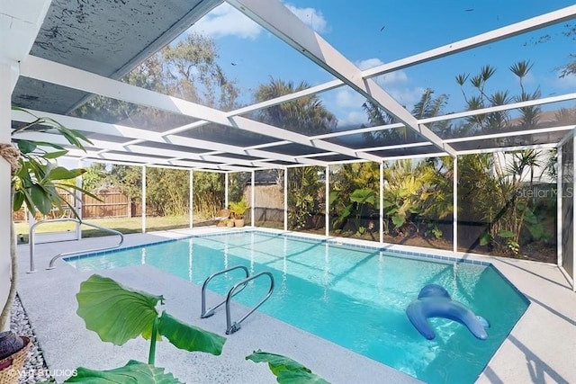 view of swimming pool featuring a lanai