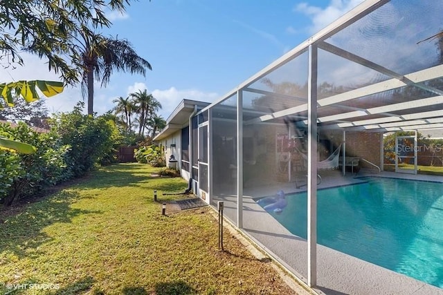 view of pool featuring a yard, a patio, and glass enclosure