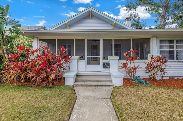 bungalow featuring a front yard and a sunroom