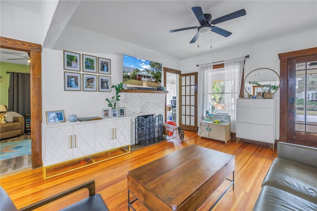 living room featuring ceiling fan, plenty of natural light, and light wood-type flooring