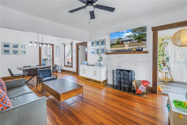 living room with hardwood / wood-style flooring, a fireplace, and ceiling fan