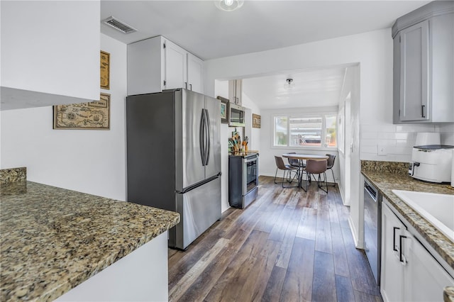 kitchen featuring sink, stainless steel appliances, tasteful backsplash, white cabinets, and dark hardwood / wood-style flooring