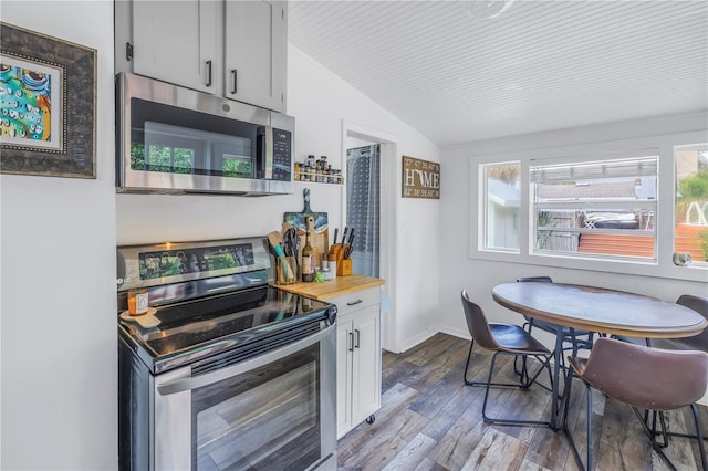 kitchen featuring stainless steel appliances, vaulted ceiling, wood-type flooring, and white cabinets