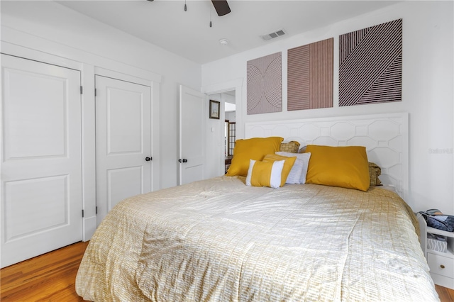 bedroom with hardwood / wood-style floors, ceiling fan, and a closet