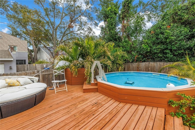 view of swimming pool featuring a jacuzzi and a deck