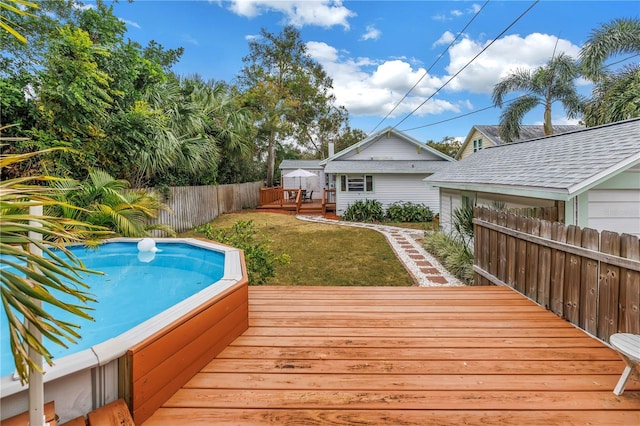 view of pool with a wooden deck and a lawn