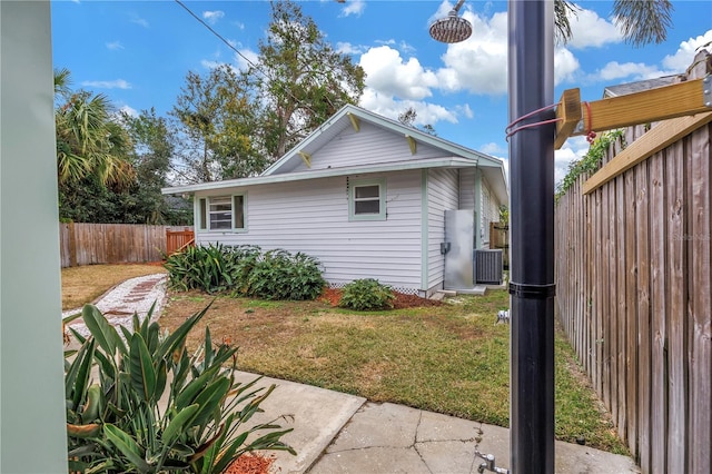 view of property exterior with central AC unit and a lawn