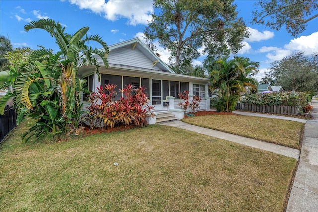 view of front of house with a sunroom and a front yard