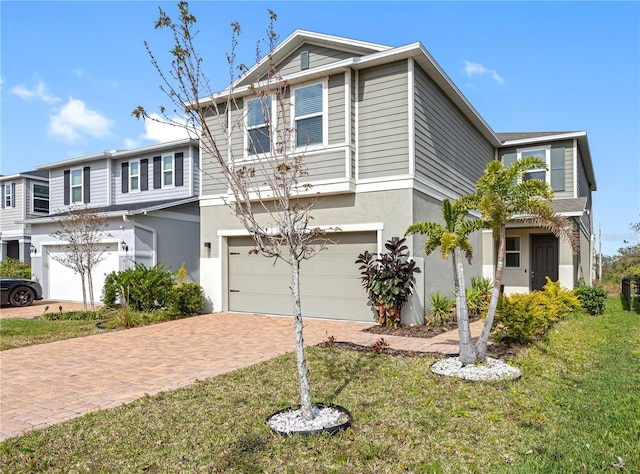 view of front of house featuring a garage, a front lawn, decorative driveway, and stucco siding