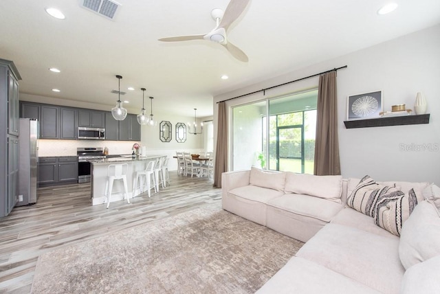 living room featuring ceiling fan and light hardwood / wood-style floors