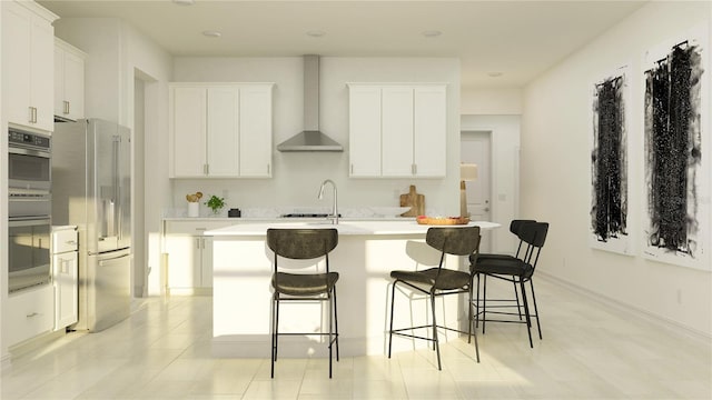 kitchen featuring white cabinetry, a kitchen island with sink, stainless steel appliances, a kitchen bar, and wall chimney exhaust hood