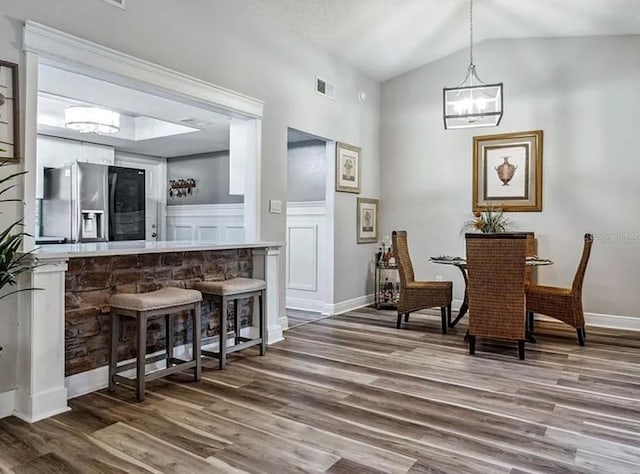 dining room with lofted ceiling and dark hardwood / wood-style floors