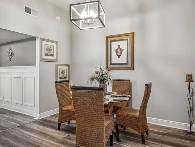 dining space featuring dark hardwood / wood-style flooring and a notable chandelier