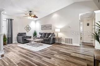 living room with ceiling fan, wood-type flooring, and vaulted ceiling