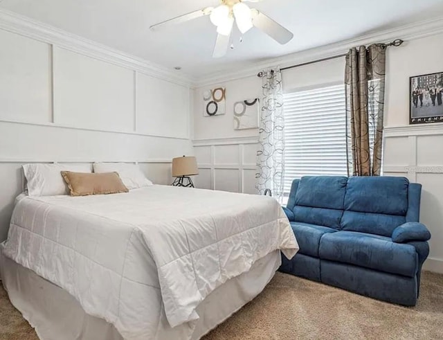 carpeted bedroom with ornamental molding and ceiling fan