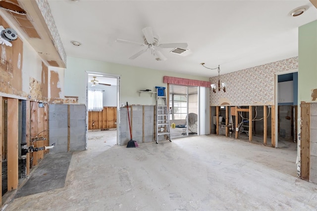 misc room featuring ceiling fan with notable chandelier