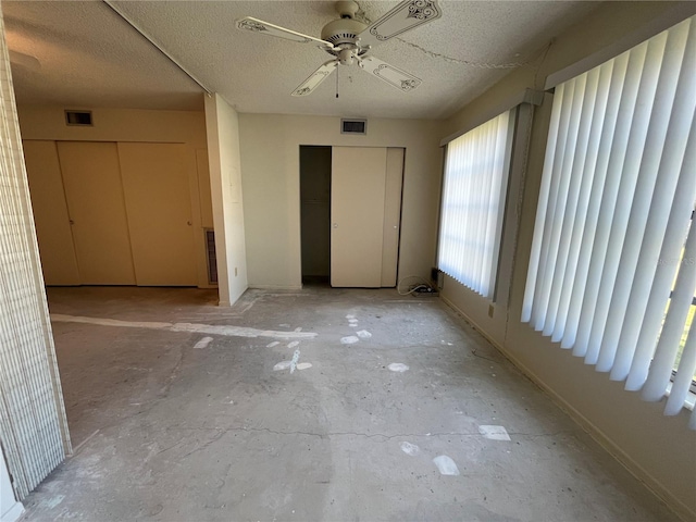 unfurnished bedroom featuring ceiling fan and a textured ceiling