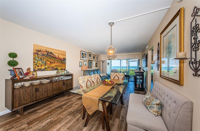 dining space with hardwood / wood-style floors and a notable chandelier