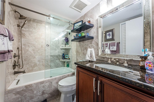 full bathroom featuring vanity, shower / bath combination with glass door, and toilet