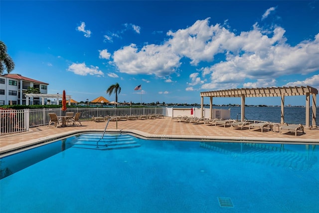 view of swimming pool featuring a water view, a pergola, and a patio area