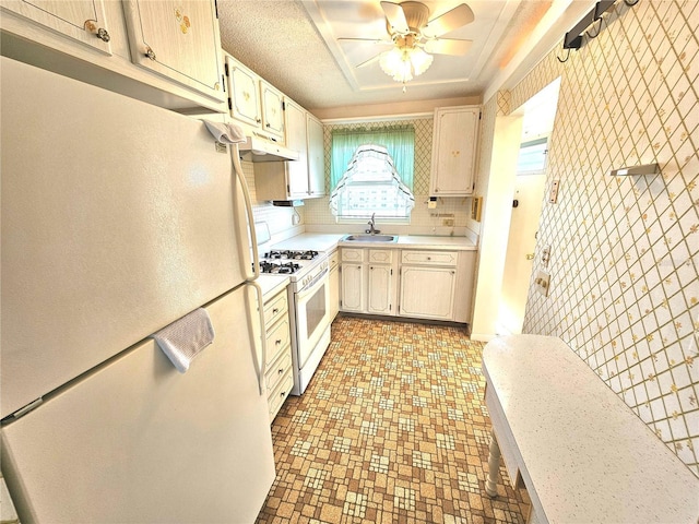 kitchen featuring ceiling fan, white appliances, sink, and decorative backsplash