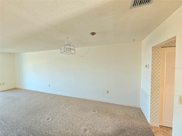 spare room with light carpet and a textured ceiling