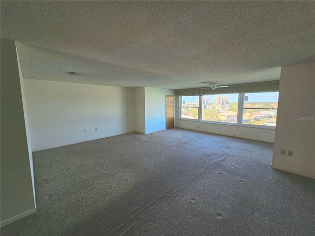 carpeted spare room featuring ceiling fan and a textured ceiling