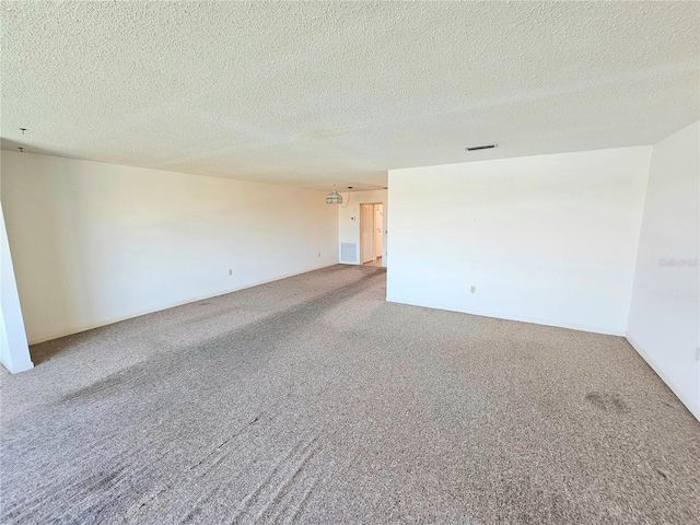 empty room featuring carpet and a textured ceiling