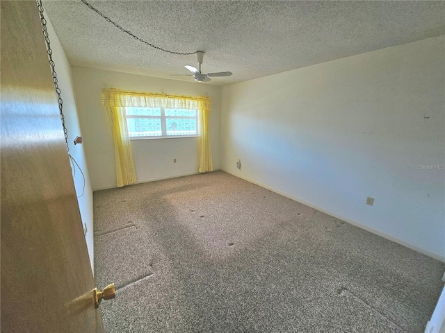 carpeted empty room with ceiling fan and a textured ceiling