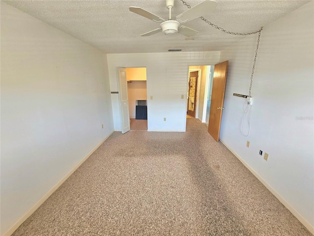 carpeted spare room with ceiling fan and a textured ceiling