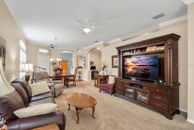 living room with ornamental molding, ceiling fan with notable chandelier, and light colored carpet