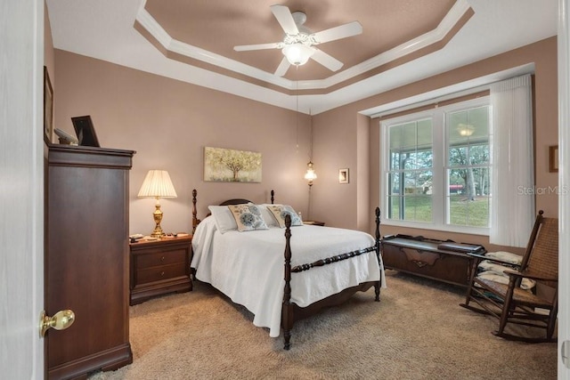 bedroom with crown molding, a raised ceiling, and light carpet