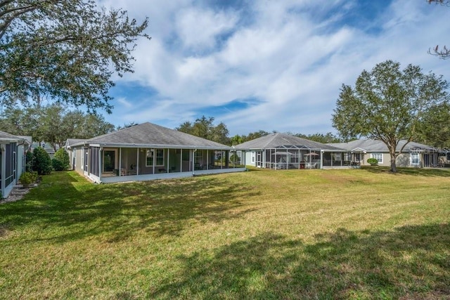 back of house featuring a yard and a sunroom