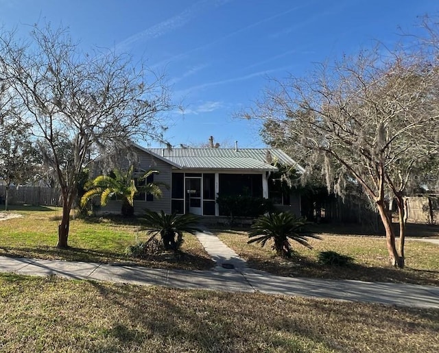 view of front of property featuring a sunroom and a front yard