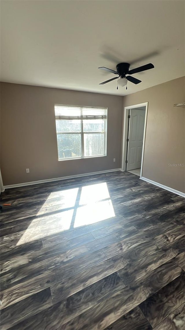 spare room with dark hardwood / wood-style floors and ceiling fan