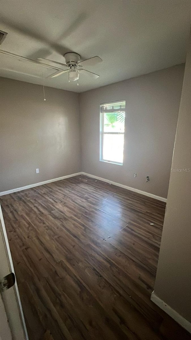 unfurnished room featuring dark wood-type flooring and ceiling fan