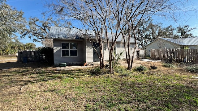 rear view of property featuring a lawn