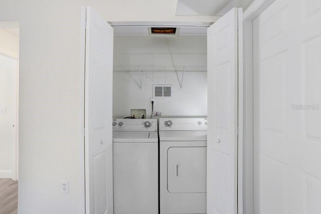 clothes washing area with washer and clothes dryer