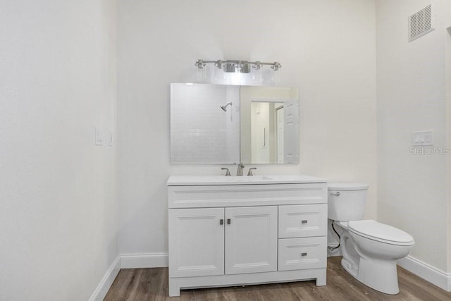 bathroom with walk in shower, vanity, toilet, and hardwood / wood-style floors